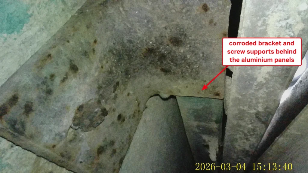 Corroded bracket and screw supports behind alum cladding